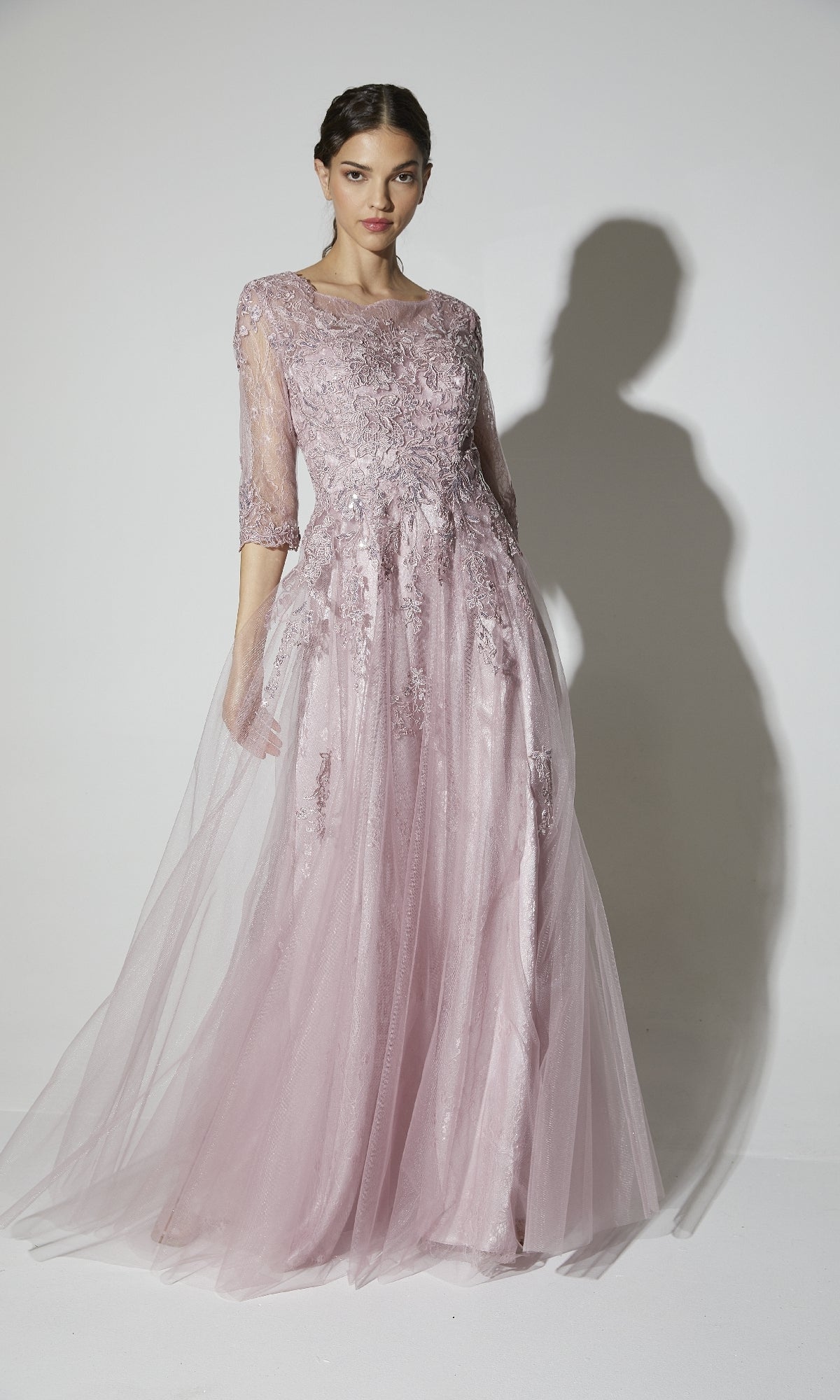 Woman in the Eureka 9660 Flowy Long Sleeve Long Formal Dress, featuring a lace bodice and sheer three-quarter sleeves, stands against a plain background.